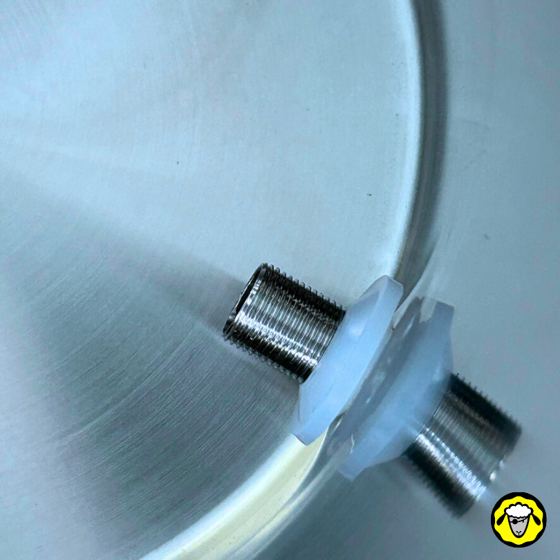 Gros plan sur un filetage métallique du robinet inox avec joint en silicone blanc fixé sur l'intérieur d'un filtre à eau en acier inoxydable.