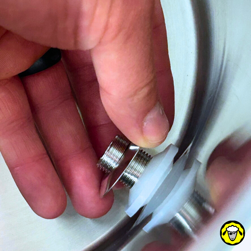 Installation d'un filetage métallique avec joint en silicone sur l'intérieur d'un filtre à eau, tenant le filetage avec une main.