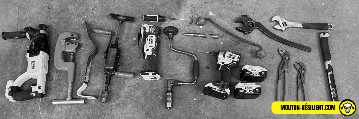 Une variété d'outils de survie alignés sur un sol en béton, comprenant des perceuses, des clés, et des tournevis, illustrant l'équipement nécessaire pour des travaux de bricolage ou de réparation en situation d'urgence