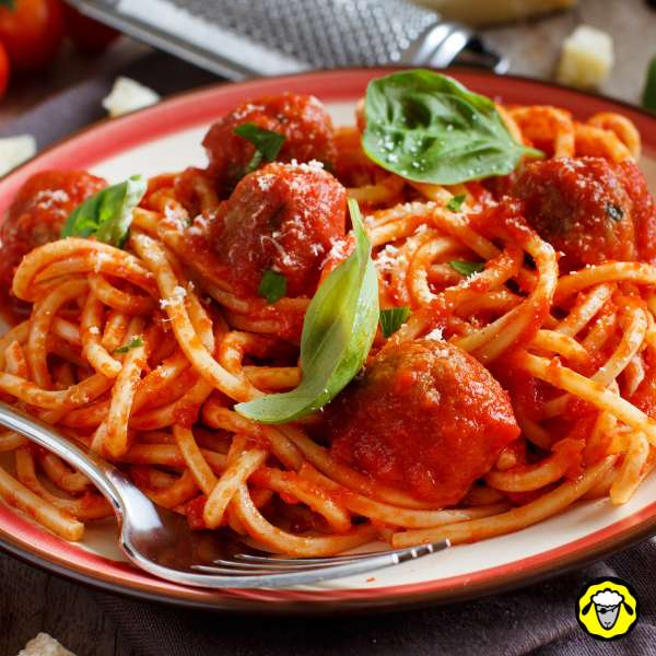 assiette-de-spaghetti-aux-boulettes Assiette de spaghetti avec sauce tomate, boulettes de viande et feuilles de basilic frais.
