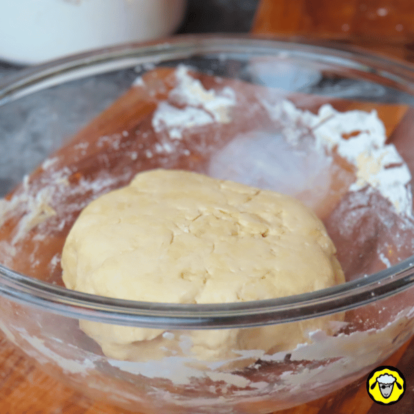 pain-maison-facile-cuit-a-la-poele-4 Une boule de pâte lisse repose dans un bol en verre après avoir été pétrie, prête pour la phase de repos.