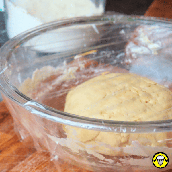 pain-maison-facile-cuit-a-la-poele-5 Le bol en verre contenant la pâte est recouvert d’un film plastique, indiquant le début du temps de repos.