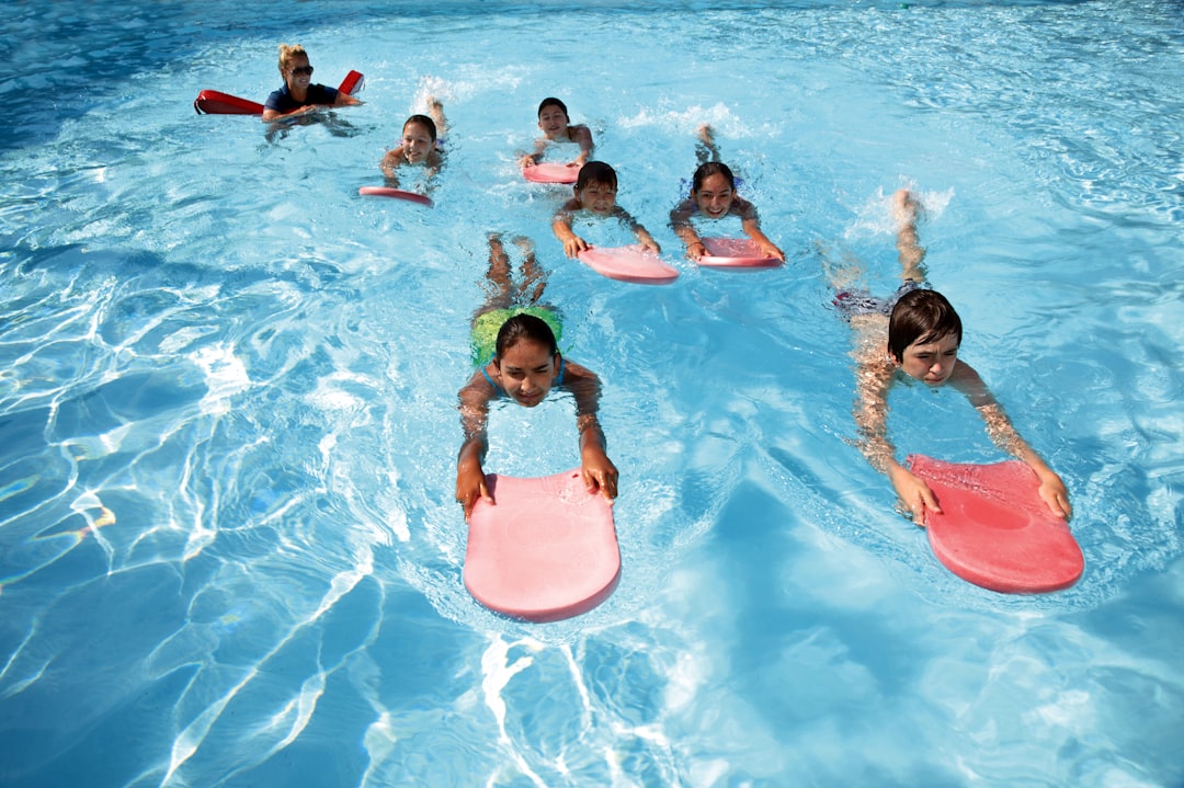 Photo by Kevin Paes a group of kids in a pool
