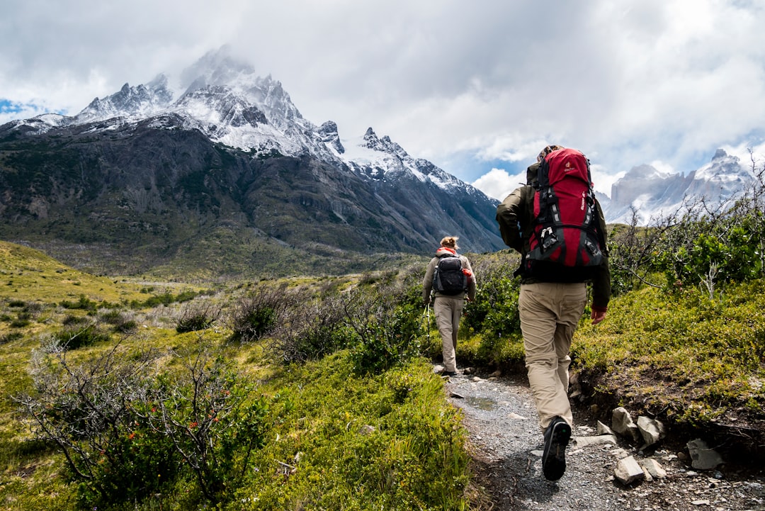 Photo by Toomas Tartes two person walking towards mountain covered with snow