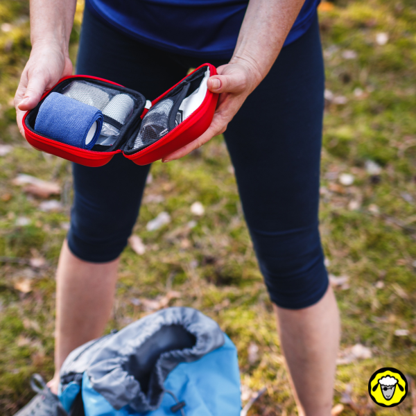 Femme tenant un trauma kit compact en pleine nature, prêt à intervenir en cas d’urgence loin des secours.