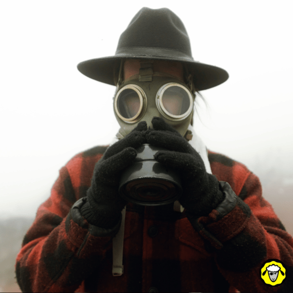 Portrait d’une personne portant un masque à gaz et un chapeau, dans un environnement brumeux. Illustration volontairement stéréotypée du survivaliste caricatural, souvent montré dans les médias. Image utilisée pour critiquer les clichés autour du préparé solitaire et extrême.