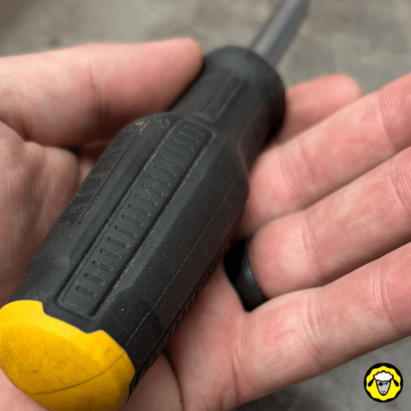 Alliance en silicone noire discrète, portée lors d’un travail manuel avec tournevis. Conçue pour les survivalistes, artisans et amateurs de solutions low-profile sécurisées.