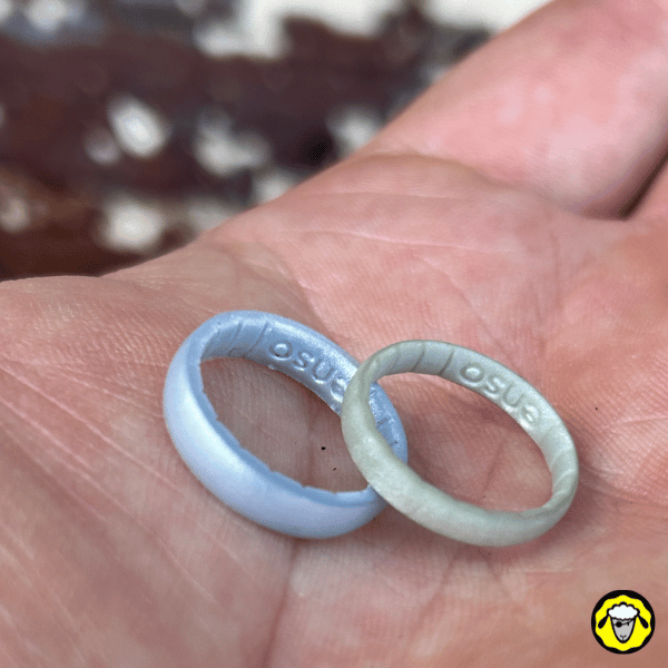 Deux alliances en silicone tactiques et résistantes, posées sur une main. Pensées pour le survivalisme, l’outdoor et les métiers manuels, elles offrent une alternative low-profile et sécurisée aux bagues métalliques.