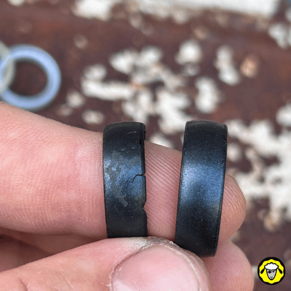 Comparaison de deux alliances tactiques en silicone noires : une intacte et une endommagée. Alternative pratique aux bagues en métal, adaptées au survivalisme, aux activités outdoor et au travail manuel.