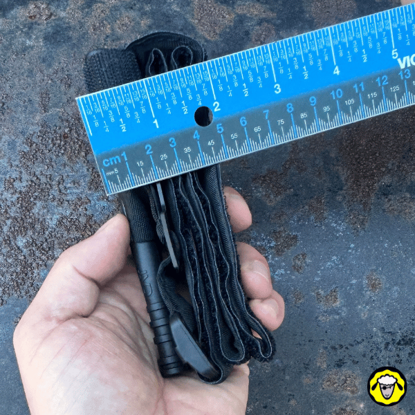 Garrot-CAT-Pliage-Tactique-Compact-8 Vue latérale du garrot CAT plié, mesuré à l’aide d’une règle, montrant l’épaisseur d’environ 4 à 5 cm.