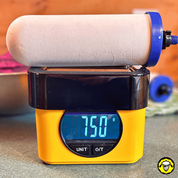 Filtre-A-Gravite-Vacances-FTO-25 Cartouche Coldstream FTO+ pesée à 750 grammes après 15 jours de séchage dans un saladier recouvert d'un torchon. La pesée permet de vérifier la quantité d’eau résiduelle avant le stockage du filtre.