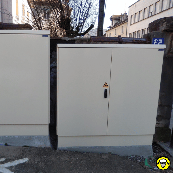Armoire de télécommunications de rue installée sur un socle en béton, utilisée pour la distribution des réseaux ADSL et fibre optique dans un environnement urbain, élément clé de l’infrastructure Internet locale.