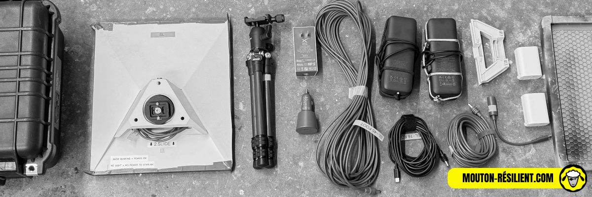 Materiel-survivaliste-coupure-internet-starlink Matériel Starlink pour autonomie Internet en situation de coupure : antenne satellite, trépied, câbles, alimentation, étui de transport et accessoires disposés à plat.