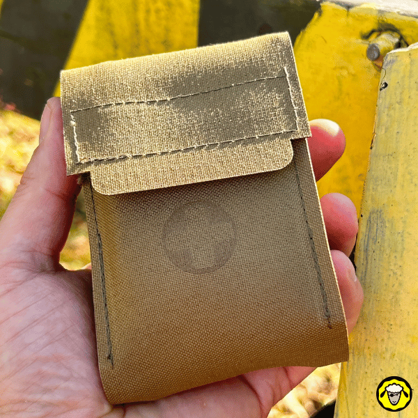 Vue en main de la pochette trauma compacte Sentinel, en nylon robuste couleur coyote, avec rabat velcro renforcé.