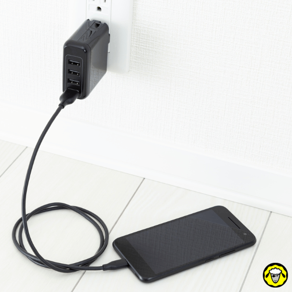 Recharge du smartphone : chargeur USB mural et téléphone en charge, base simple pour garder l’EDC numérique opérationnel
