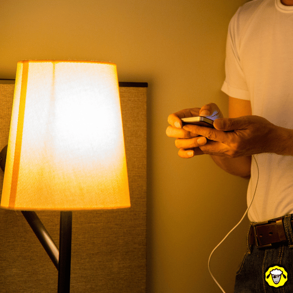 Gestion batterie EDC : personne rechargeant son smartphone avec un câble, routine utile avant de dormir.