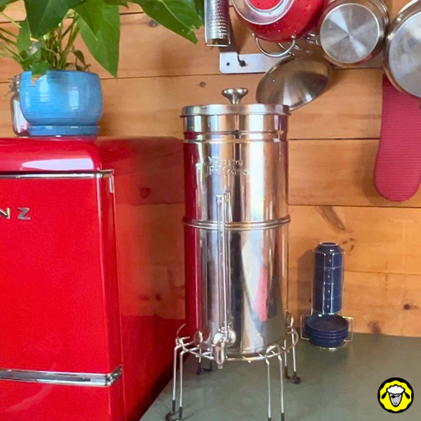 Un filtre à gravité de marque Pure Filters, posé sur un plan de travail de cuisine, à côté d'un frigo.