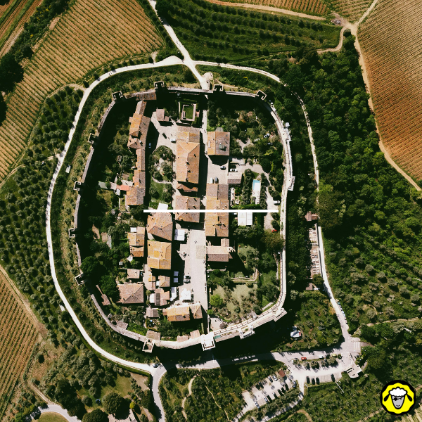 Vue aérienne d une ferme fortifiée entourée de remparts au milieu de champs et de végétation