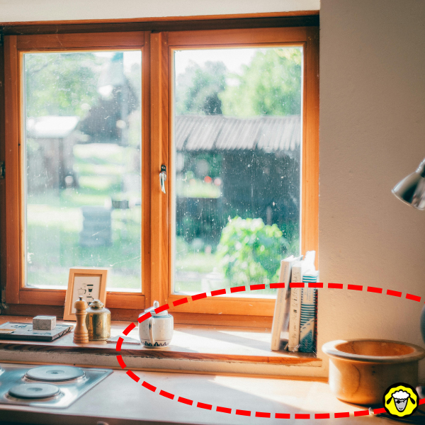 Fenêtre en bois avec rayonnement solaire direct sur l’appui Fenêtre en bois éclairée par le soleil avec une zone chaude sur l’appui de fenêtre et des objets posés dessus