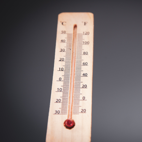 Thermomètre indiquant une forte température en Celsius et Fahrenheit Thermomètre en bois affichant une température élevée, avec échelle en degrés Celsius et Fahrenheit