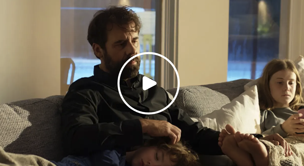 Megantic-Episode-8 Extrait de l’épisode 6 de Mégantic : un père est assis sur un canapé avec ses enfants dans une scène familiale.