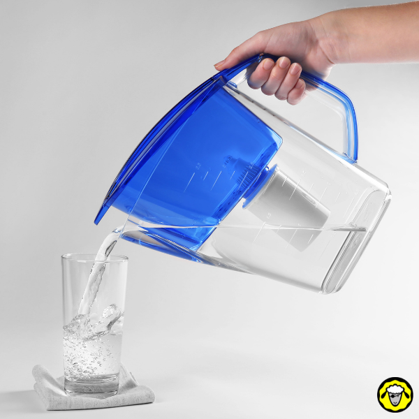 Carafe filtrante versant de l’eau dans un verre Une carafe filtrante bleue verse de l'eau dans un verre.