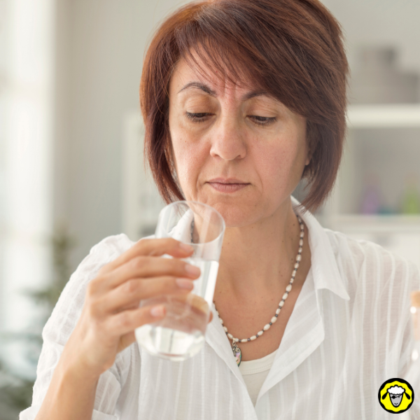 Femme observant un verre d'eau Femme regardant un verre d'eau à moitié plein