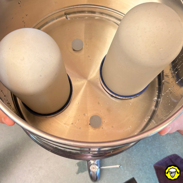 Filtre à gravité avec cartouches filtrantes dans une cuve Vue du dessus d’un filtre à gravité avec deux cartouches filtrantes dans une cuve en métal